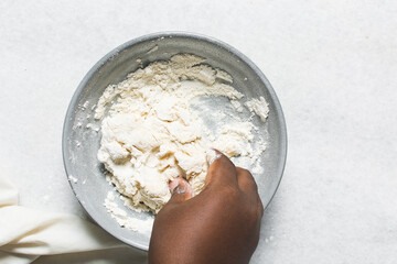 Overhead view of crackers dough being mixed in grey bowl, top view of homemade herb crackers dough being mixed in bowl, process of making crackers