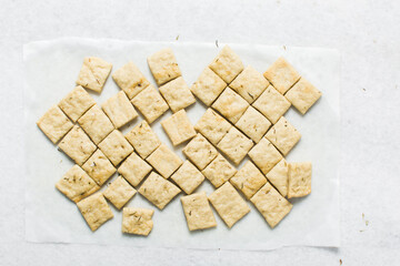Overhead view of homemade crackers on parchment paper, top view of freshly baked cracker biscuits, process of making crackers