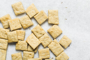 Overhead view of homemade crackers on parchment paper, top view of freshly baked cracker biscuits, process of making crackers