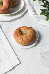 Overhead view of freshly baked bagels on white serving tray, top view of homemade bagels on white plate, process of making bagels