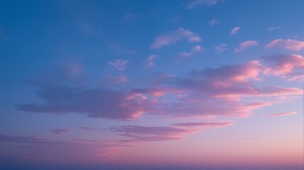 Pink and blue clouds in clear sky at dusk.