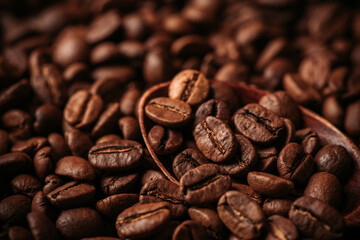 Wooden spoon on the roasted coffee beans on the wooden table. Warm colors background with coffee beans. Selective focus. Shallow depth of field.