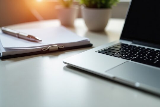 Simple desk setup with laptop, notepad, and pen, organized, essential, workspace