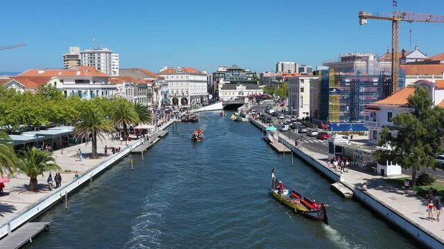 Aerial view of Ria de Aveiro with passing ships and lines of buildings on a sunny day