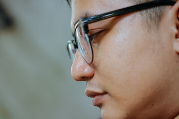 close up side view of the nose and mouth of a man wearing glasses