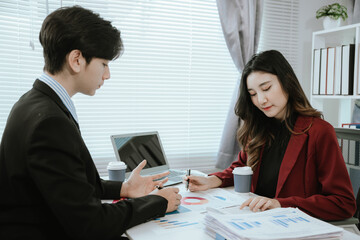 Team of corporate professionals working together in modern office to analyze financial charts and business reports. Businesswoman leading strategic discussion.