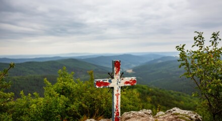 Obraz premium Scenic view of a weathered cross overlooking a lush green valley