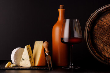 A refined selection of aged cheeses presented on a board, accompanied by a glasses of wine