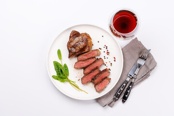 A perfectly cooked sliced striploin steak with a juicy, tender texture, served alongside a glass of rich red wine