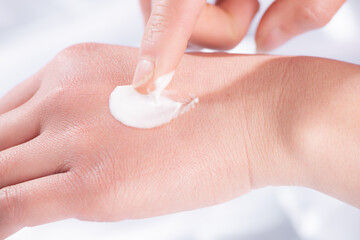 Cosmetic texture white creamy swatch on woman hand 
