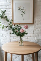 Pink flowers in vase, wooden table, framed art, white brick wall