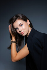 Businesswoman adjusting her hair wearing golden watch and earrings