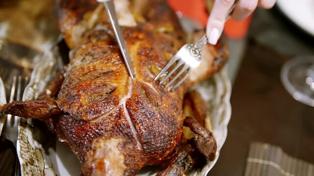 Carving roasted whole turkey at festive dinner table