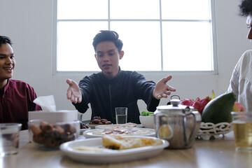 Diverse Happy Muslim Friends Having Iftar Dinner Together on Ramadan Feast at Dining Table