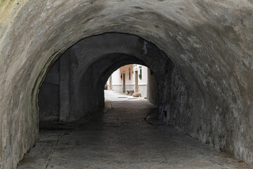 Obraz premium Cobblestone street going through a dark tunnel in Radovljica, Slovenia
