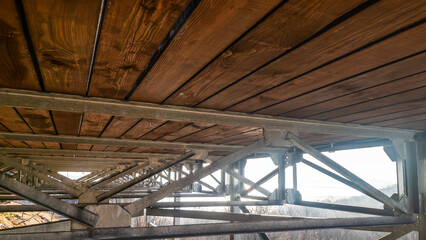 Galvanized metal supports holding up an outdoor terrace made of solid wooden planks, showcasing modern, durable construction and architectural design.