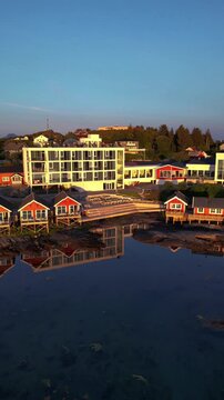 Vertical Aerial drone shot of panning around the shoreline of Lovund Island, showing traditional Norwegian Hyttes and the Lovund Hotel. Lovund, Norway