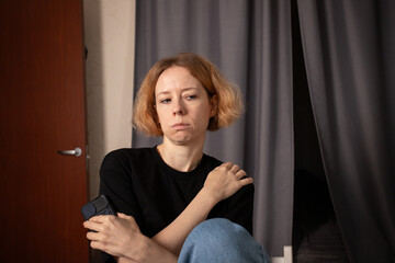 Sad woman with phone at home, experiencing solitude and introspection, using technology to navigate...