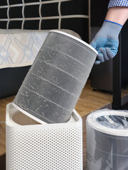 A man changes a dirty air filter to improve the air quality in an apartment or house.