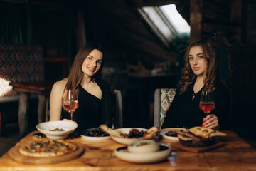 Two Women Enjoying Drinks and Dining in an Intimate Ambient Setting