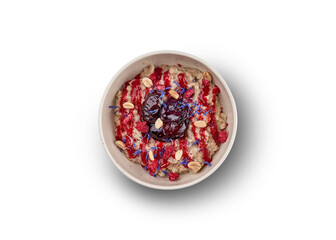 A bowl of oatmeal porridge with berries, nuts, and edible flowers, perfect for a healthy breakfast.