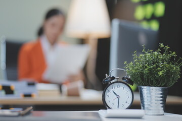 Young adorable Asian businesswoman working with work document during the night, working overtime at...