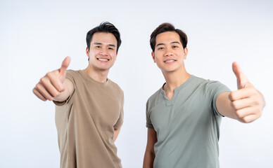 Two smiling men giving thumbs up. Optimistic and positive expression of two people in casual...