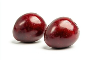 Fototapeta premium Two dark red plums displayed with elegance on pure white background showcasing rich color texture and perfect shape