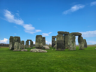 Stonehenge in England with green grass and a blue sky