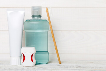 Mouthwash and other oral hygiene products on colored table top view with copy space. Flat lay. Dental hygiene. Oral care products and space for text on light background. concept