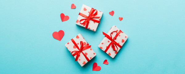 Valentine day composition Background: red gift box with bow and heart. Christmas present. View from above. Holday greeting card