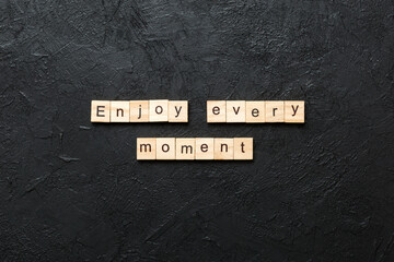 Enjoy Every Moment word written on wood block. Enjoy Every Moment text on cement table for your...