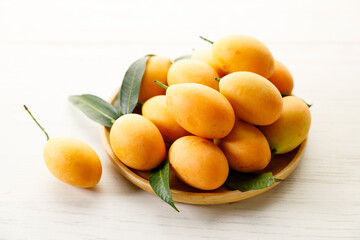 Plum Mango or Marian Plum fruit in wooden tray.
