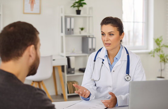 Professional woman doctor gives consultancy to male patient in her private clinic, discuss checkup results, have medical appointment, giving useful recommendations. Health care concept