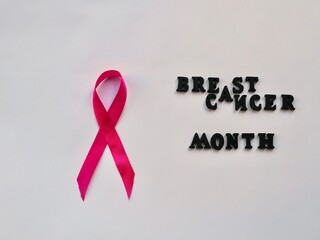 Concept of Breast Cancer Month in Women. Symbol pink ribbon in hands on white background close-up