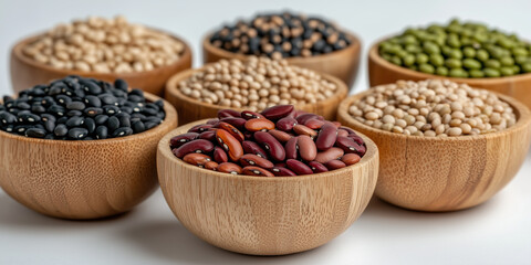 Fototapeta premium Wooden bowls filled with various grains and legumes on white background