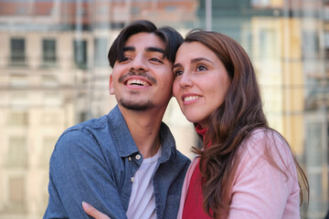 Young Couple Smiling and Embracing Outdoors in Urban Setting