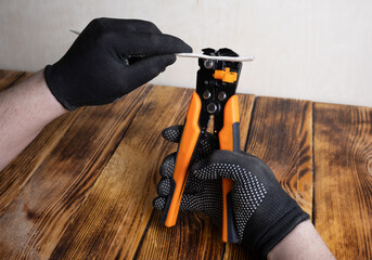 Man hands with glove using wire Stripping tool