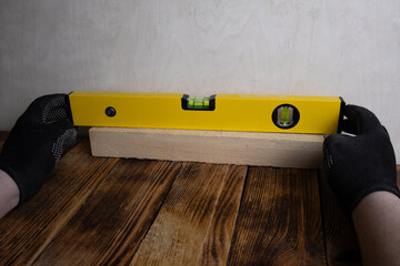 Male hands in gloves using spirit level