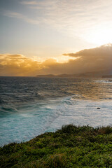 Obraz premium Golden Glow sunset over ocean cliffs