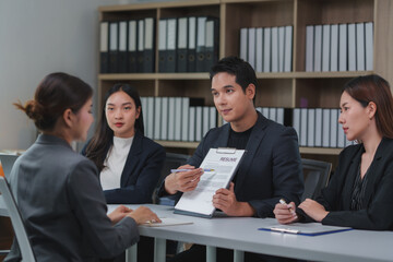 Managers interviewing job applicant and reviewing resume during job interview