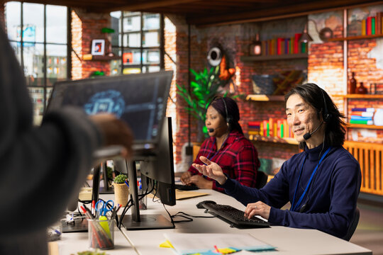 Call center multiethnic team using artificial intelligence chatbot to provide multilingual support. Multiracial customer support colleagues leveraging AI tools to translate clients interactions