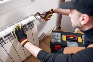 Central heating mechanic and handyman fixing home radiator, gas crisis and seasonal issues.