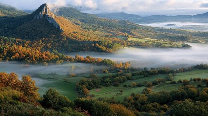Obraz premium A beautiful morning mist rolling over the green valleys of the Auvergne volcano, creating a magical atmosphere.