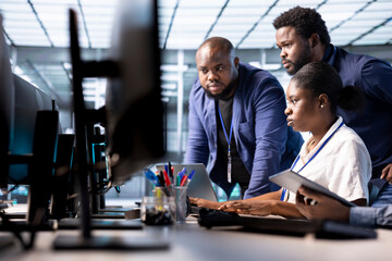 Team of data center office technicians using programming languages to construct algorithms and build applications. Server hub IT staff members debugging and optimizing code