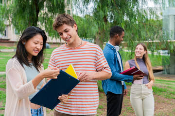 Two young students engaged in a lively discussion while reviewing their colorful folders, showcasing collaboration and enthusiasm for their academic pursuits outside