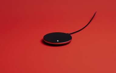 Black Wireless Charging Pad on Red Background