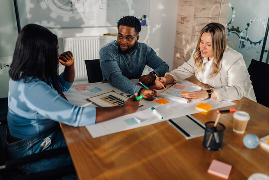Marketing team analyzing charts and brainstorming new ideas during meeting