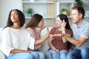 Four angry diverse friends arguing at home