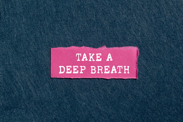 Take a deep breath message written on ripped torn pink paper piece on gray background. Conceptual...